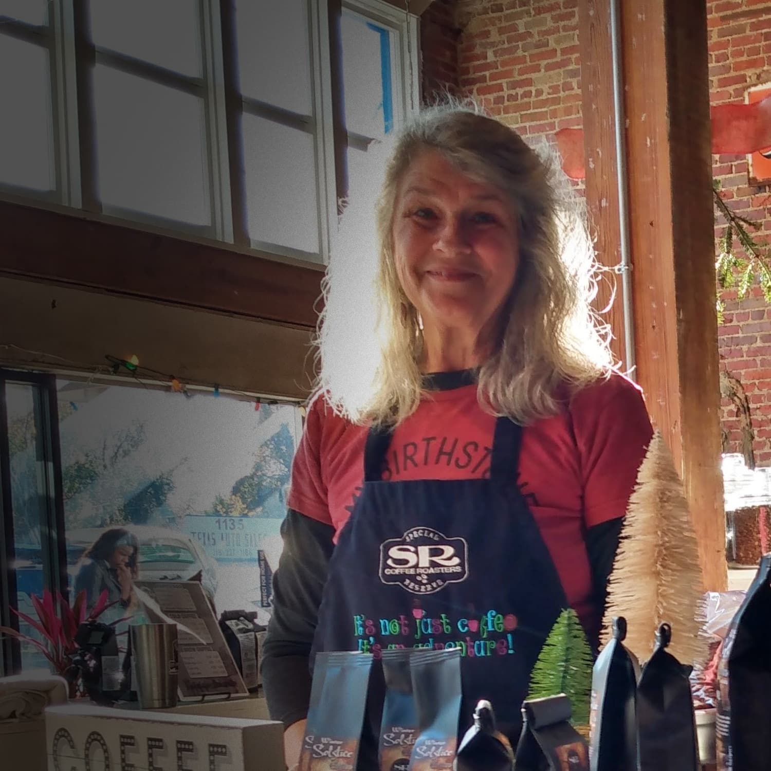 Donna, owner of Special Reserve Coffee, smiling at the shop counter